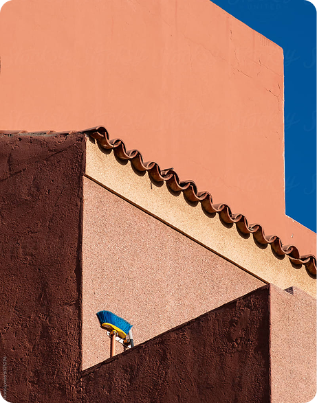 Architectural detail of a building featuring contrasting colors, textured walls, and a broom attached to the wall, symbolizing brand clarity and narrative structure in modern marketing strategies.