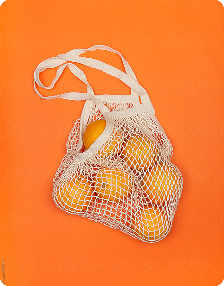 Mesh bag filled with oranges on an orange background, representing freshness and sustainability in modern product marketing.