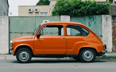 Orange vintage car parked on a street, showcasing its classic design and retro style, relevant to discussions on adaptability in AI-driven marketing strategies.