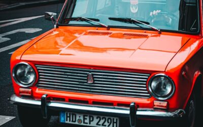 Orange vintage car parked on a city street, reflecting modern urban life and nostalgia in the context of evolving digital marketing strategies.