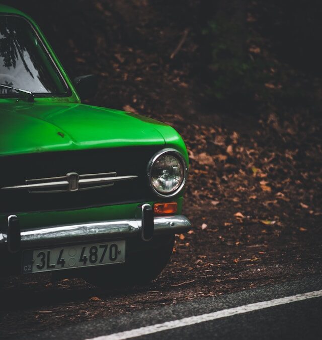 Green vintage car parked on a forested road, emphasizing nostalgia and outdoor exploration related to AI search visibility strategies.